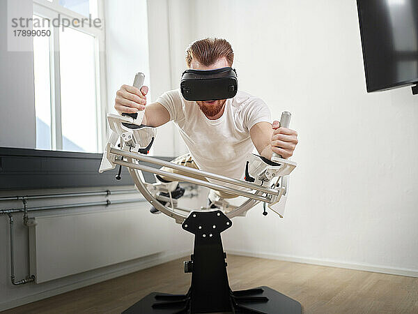 Junger Mann mit VR-Brille übt Flugsimulator