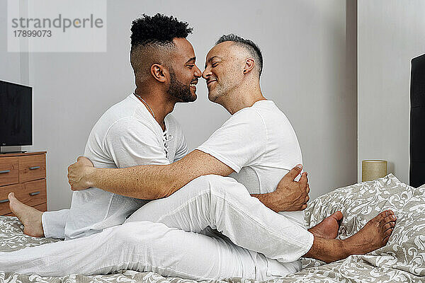 Romantisches schwules Paar kuschelt sich zu Hause im Bett