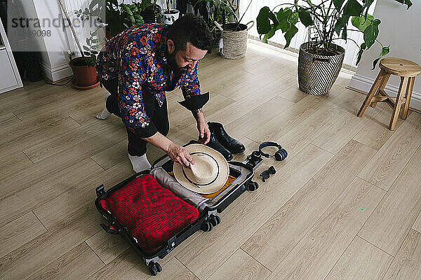 Reifer Mann packt zu Hause Koffer