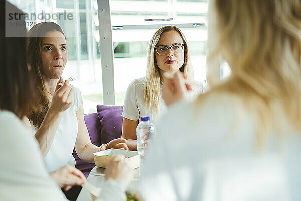 Geschäftskollegen essen gemeinsam am Tisch zu Mittag