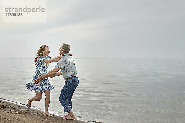 Junge Frau genießt mit Vater am Strand