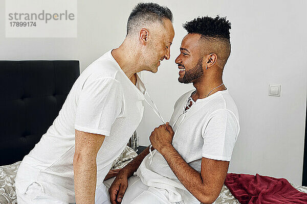 Liebevolles homosexuelles Paar  das zu Hause im Bett romantisiert