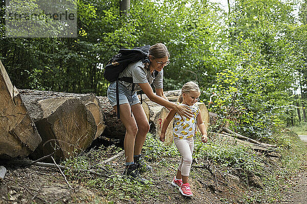 Lächelnde Frau mit Tochter im Wald