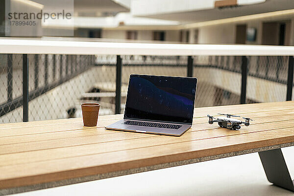 Laptop und Drohne mit Kaffeetasse auf dem Tisch im Büro