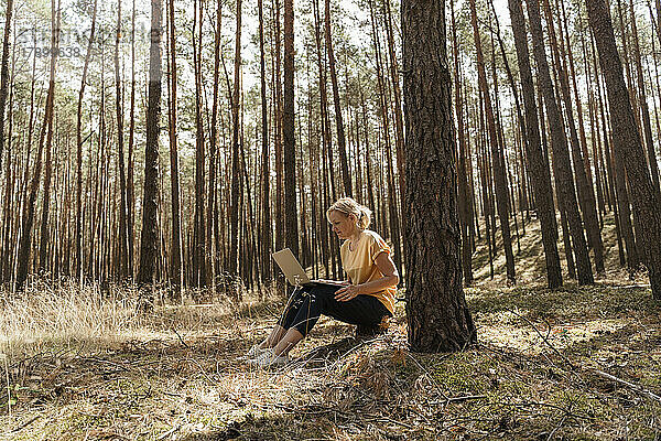 Reife Frau benutzt Laptop im Wald