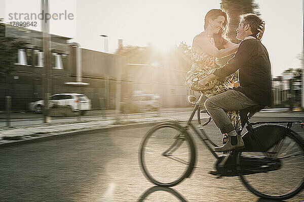 Ein Paar genießt an einem sonnigen Tag eine Radtour auf der Straße