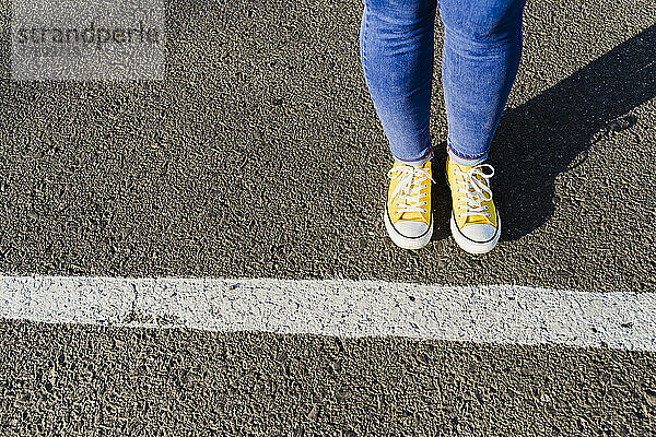 Woman standing near white line drawn on road