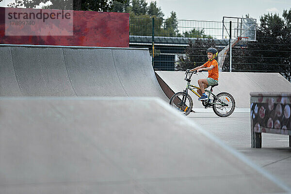 Junge übt mit BMX-Fahrrad im Skateboardpark
