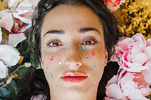 Sad young woman with teardrop stickers on cheeks