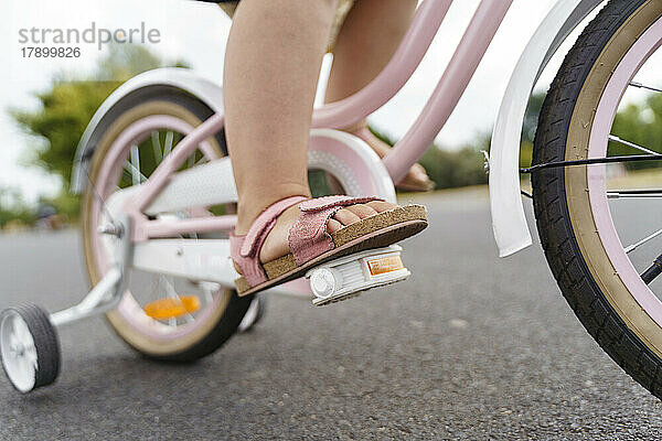 Mädchen fährt Fahrrad auf der Straße