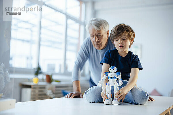 Junge mit Robotermodell von Großvater zu Hause