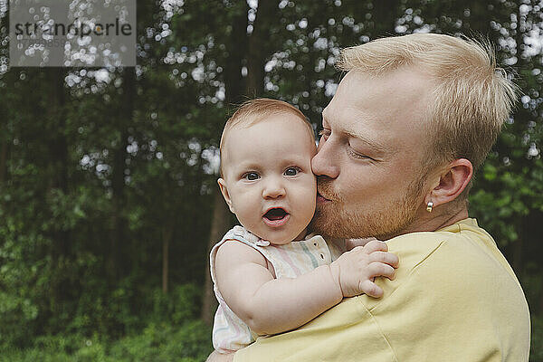 Vater küsst süßes kleines Mädchen im Park