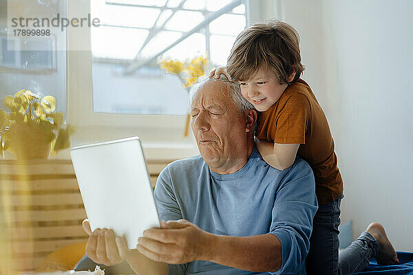 Großvater macht zu Hause ein Selfie mit seinem Enkel über einen Tablet-PC