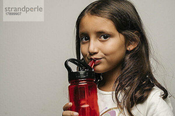 Nettes Mädchen trinkt Wasser aus der Flasche