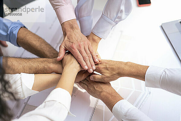 Business people stacking hands in meeting