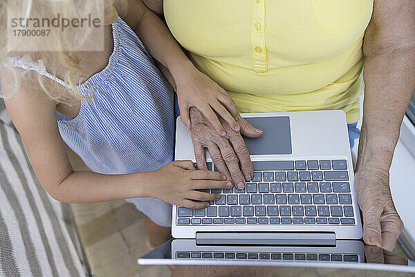 Ältere Frau benutzt Laptop mit Enkelin