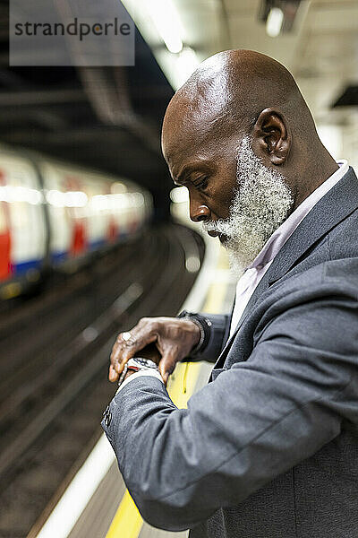 Ältere Passagiere überprüfen die Zeit am U-Bahnsteig