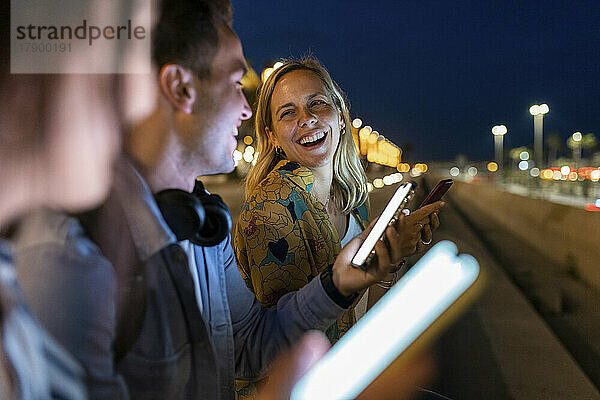 Cheerful woman enjoying with friends at night