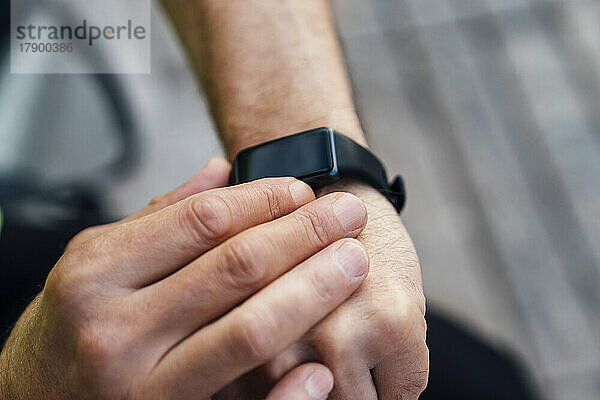 Reifer Mann misst die Herzfrequenz mit einer Smartwatch
