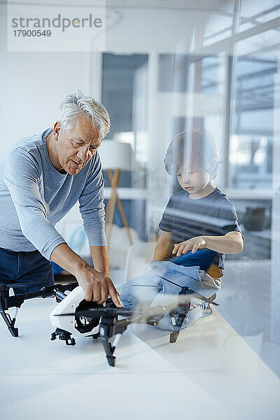 Älterer Mann untersucht Drohne von Enkel zu Hause