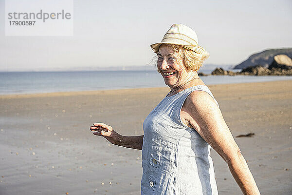 Fröhliche ältere Frau genießt Urlaub am Strand