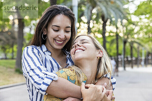 Glückliche Frau umarmt Freundin im Park