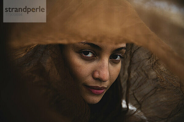 Confident young woman under brown scarf