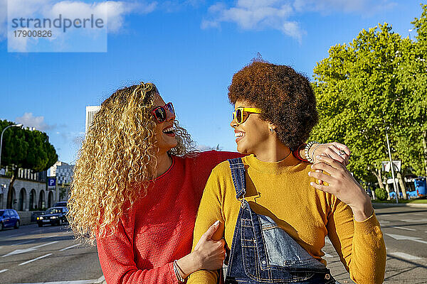 Happy lesbian couple wearing sunglasses on sunny day