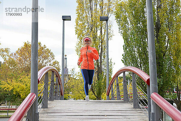 Lächelnde Sportlerin joggt im Park