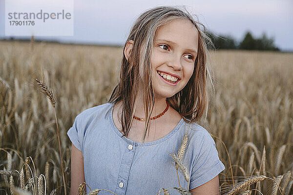 Lächelndes Mädchen inmitten von Feldfrüchten auf dem Bauernhof