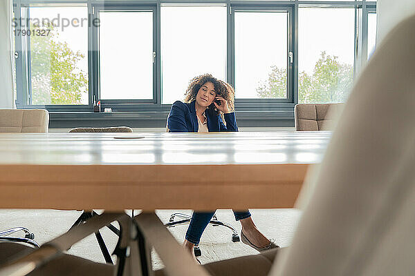 Geschäftsfrau entspannt sich auf einem Stuhl im Sitzungssaal