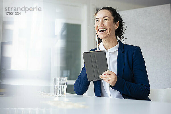 Glückliche Geschäftsfrau mit Tablet-PC und digitalisiertem Stift