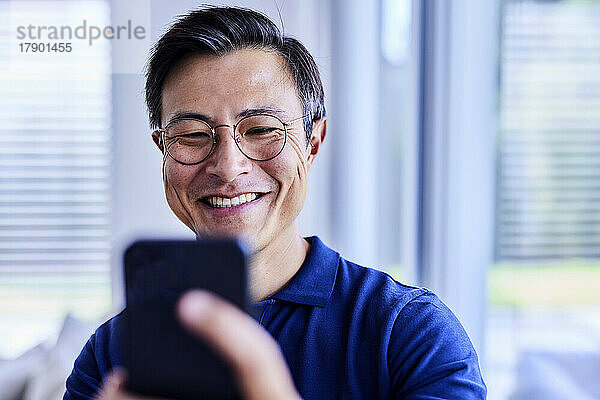 Glücklicher Mann mit Brille  der ein Selfie mit dem Handy macht