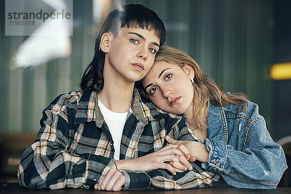 Young lesbian couple sitting at table in restaurant
