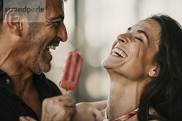 Fröhliches Paar genießt gemeinsam Eis