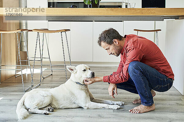 Mann streichelt seinen Hund zu Hause