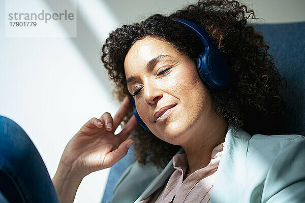 Geschäftsfrau hört Musik und entspannt sich im Büro