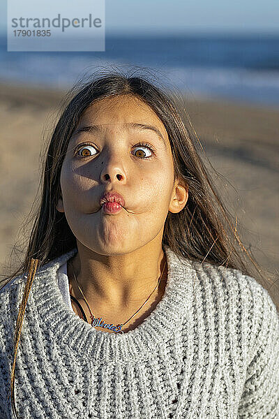 Mädchen im Pullover macht an einem sonnigen Tag Gesicht
