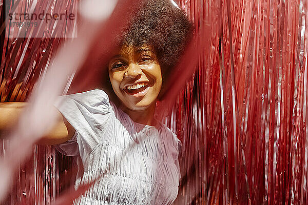 Happy young woman having fun amidst tinsels