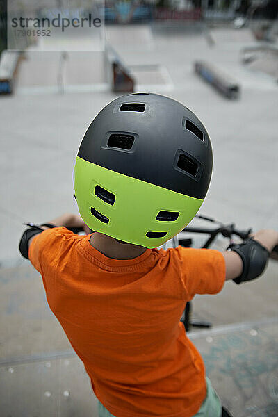 Junge mit Helm auf BMX-Fahrrad im Skatepark