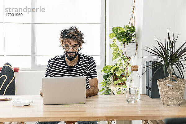 Freiberufler nutzt Laptop am Schreibtisch im Heimbüro