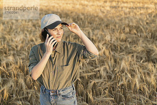 Frau am Telefon steht im Feld