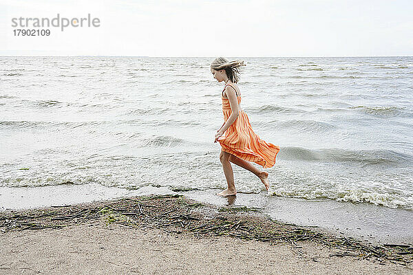 Girl walking on sea shore at beach