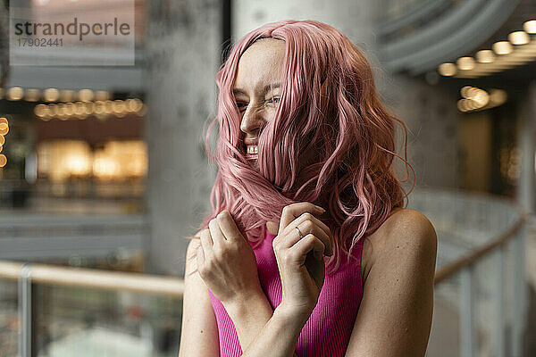 Glückliche Frau  die mit rosa gefärbten Haaren genießt