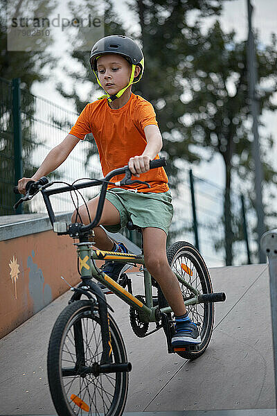 Junge fährt BMX-Fahrrad auf der Sportrampe