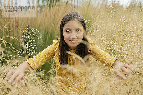 Lächelndes Mädchen inmitten von Gras im Feld