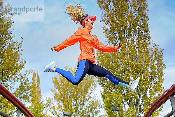 Verspielte Sportlerin springt im Park