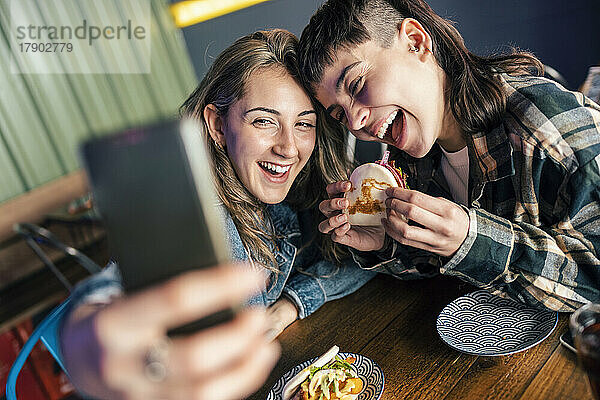 Fröhliches lesbisches Paar macht Selfie per Smartphone