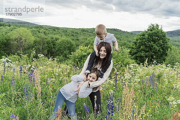 Mutter mit Tochter und Sohn auf der Lupinenblumenwiese