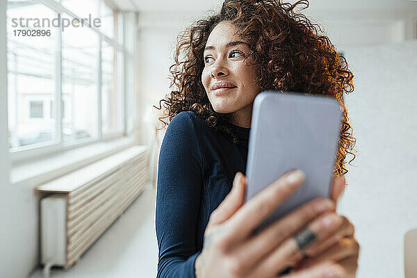 Lächelnde schöne Frau  die ein Selfie mit dem Smartphone macht